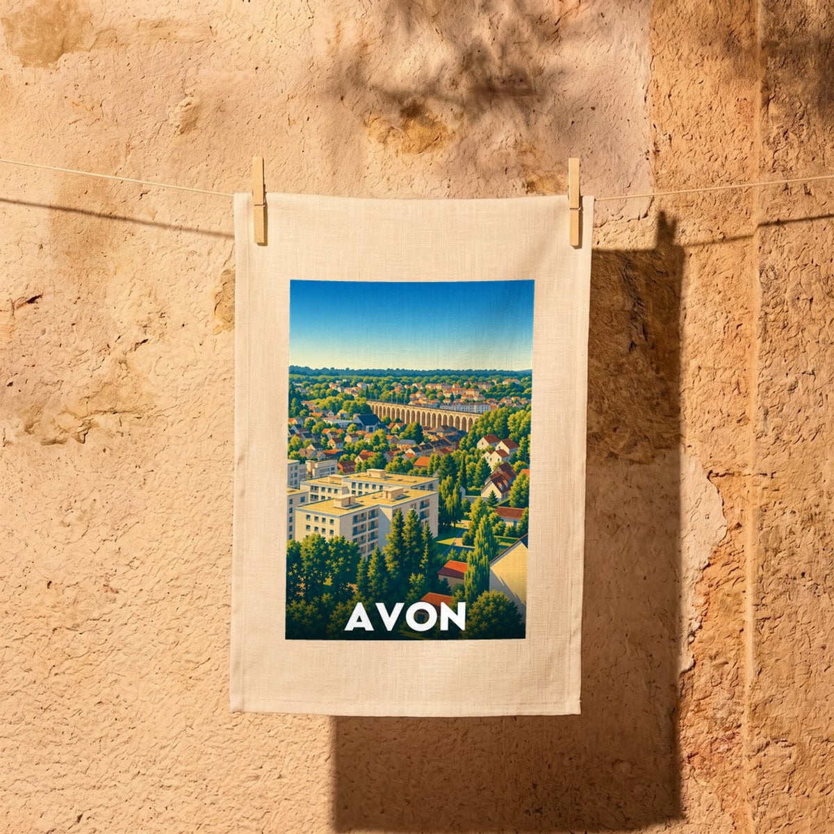 Torchon souvenir de la ville d'Avon avec une illustration stylisée de son paysage urbain et de son viaduc.