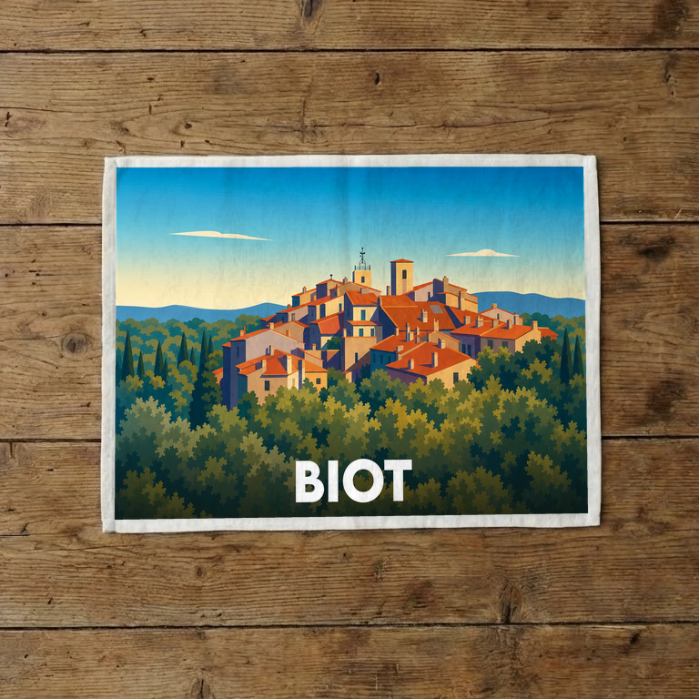 Torchon souvenir de la ville de Biot orné d'une illustration stylisée représentant le village perché et sa forêt.