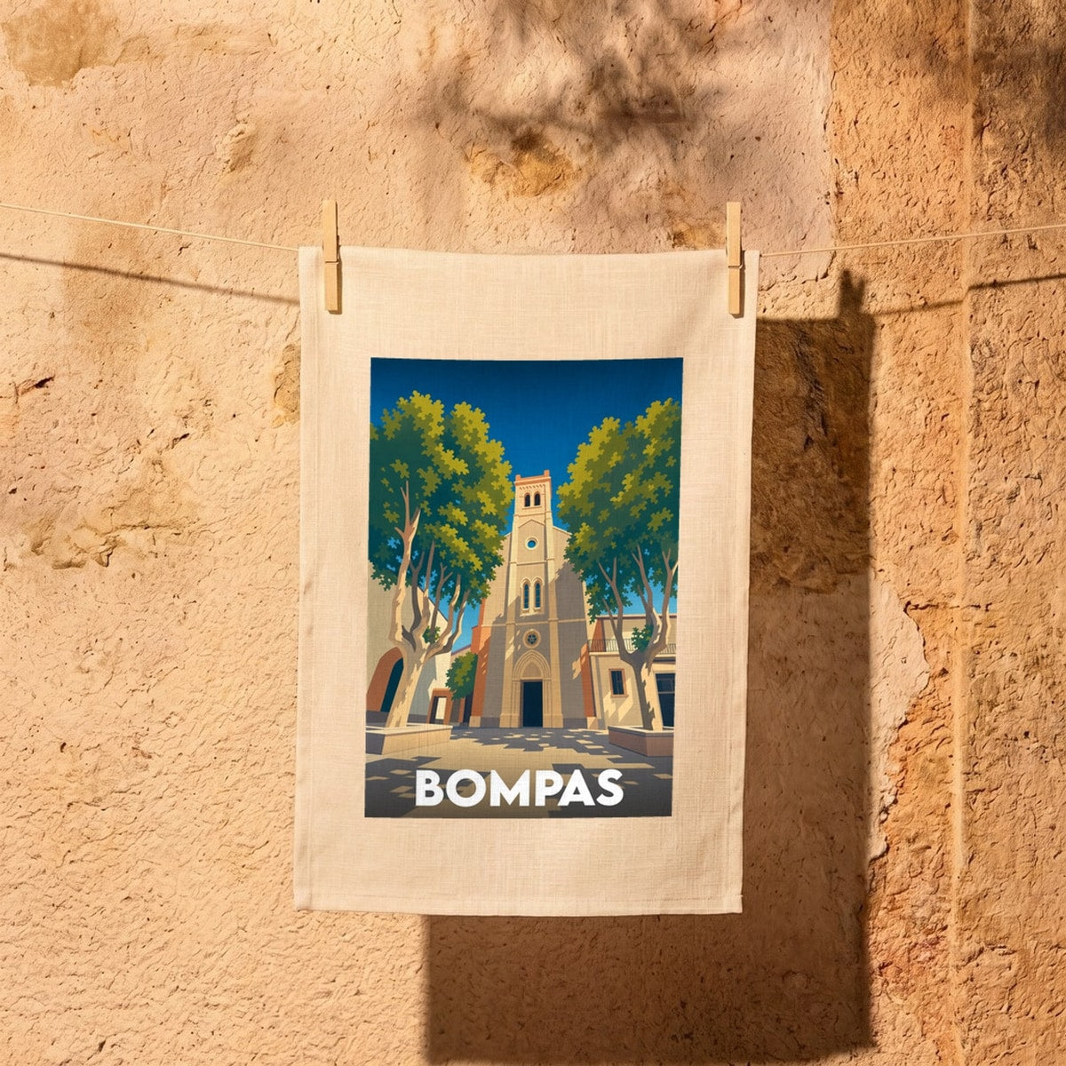 Torchon souvenir de la ville de Bompas avec une illustration stylisée de son église et de ses platanes.