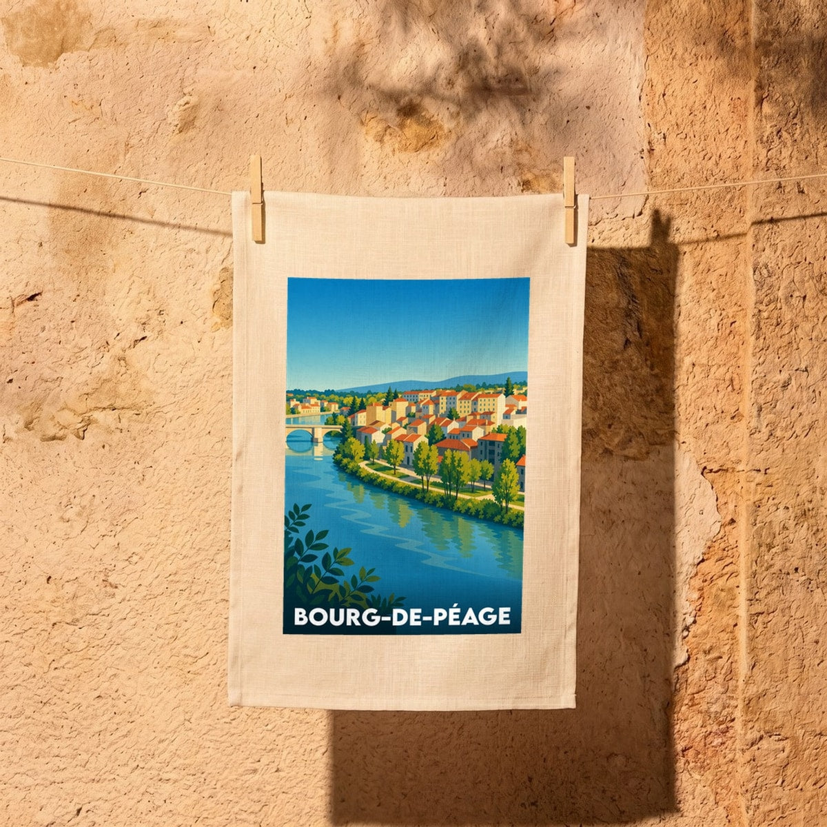Torchon souvenir de la ville de Bourg-de-Péage illustré d'un paysage urbain stylisé au bord de l'eau.
