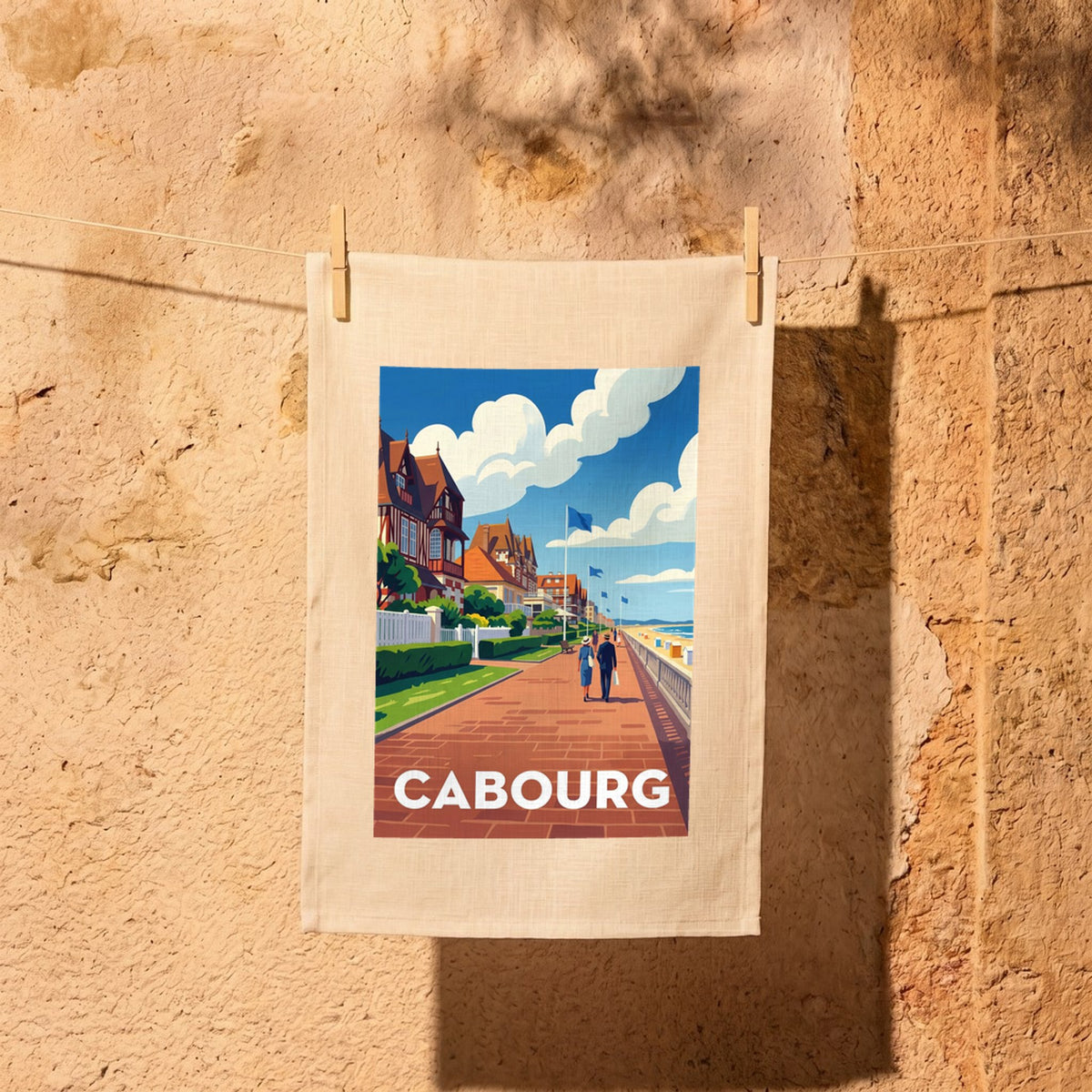 Torchon souvenir de la ville de Cabourg avec une illustration stylisée de son front de mer.