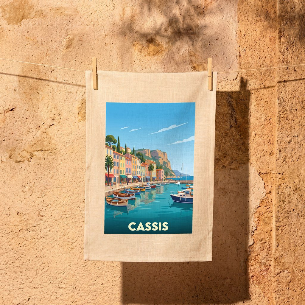 Torchon souvenir de la ville de Cassis avec une illustration stylisée du port et de ses bateaux.