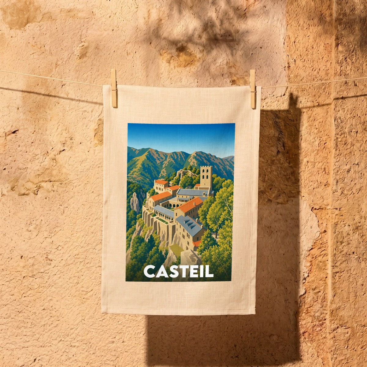 Torchon souvenir de la ville de Casteil avec une illustration stylisée de son abbaye nichée dans les montagnes.
