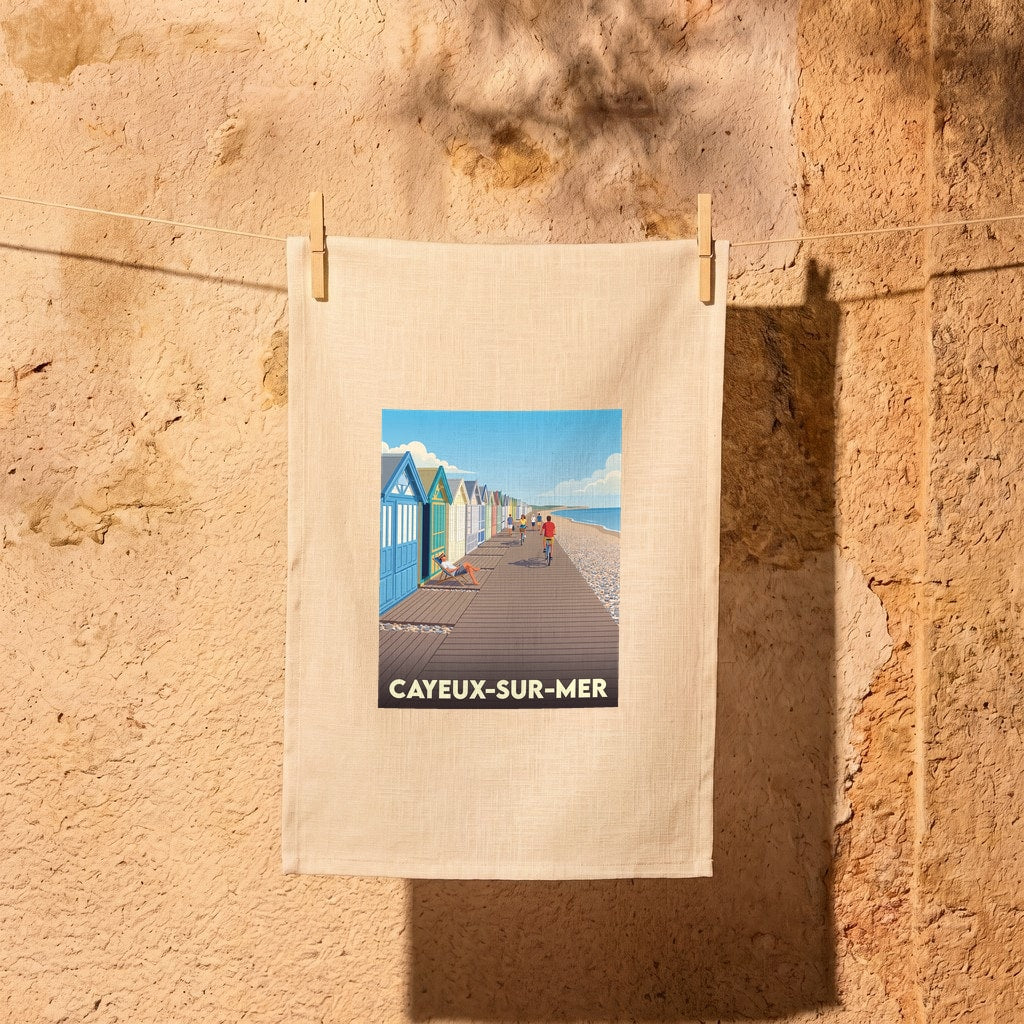 Torchon souvenir de la ville de Cayeux-sur-Mer avec une illustration stylisée de sa promenade et de ses cabines de plage colorées.