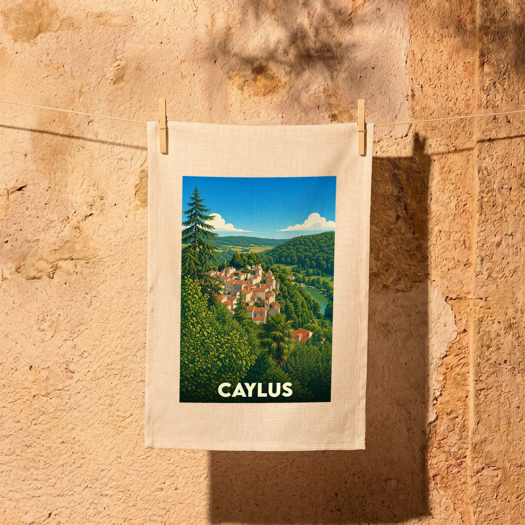 Torchon souvenir de la ville de Caylus illustré d'un paysage de village pittoresque suspendu à une corde à linge.