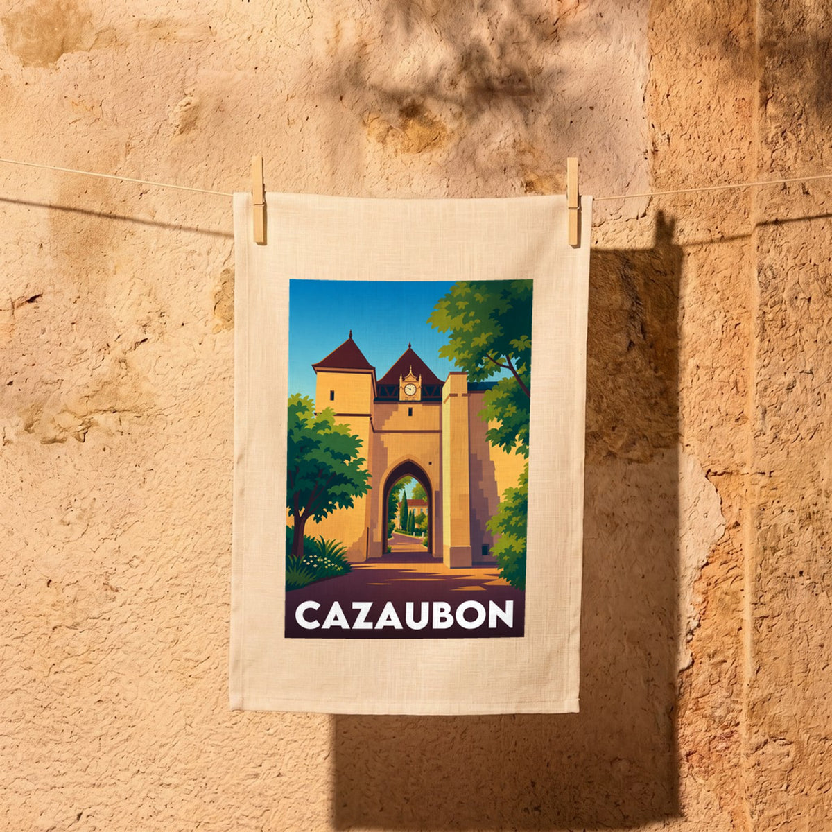 Torchon souvenir de la ville de Cazaubon avec une illustration stylisée de sa porte fortifiée.