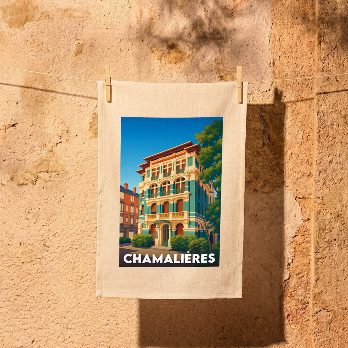 Torchon souvenir de la ville de Chamalières avec une illustration stylisée de bâtiments colorés.