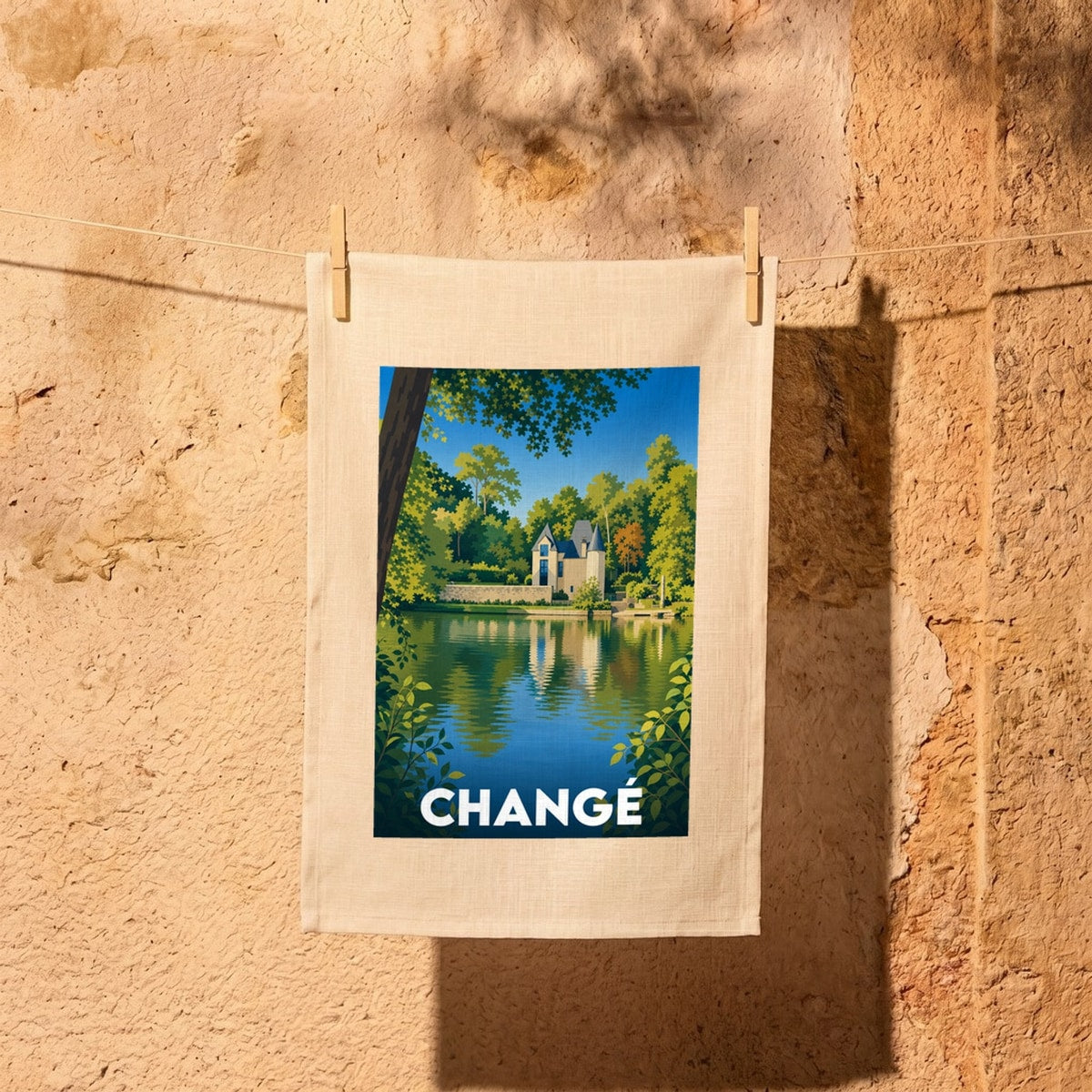 Torchon souvenir de la ville de Changé avec une illustration stylisée d'un manoir au bord de l'eau.