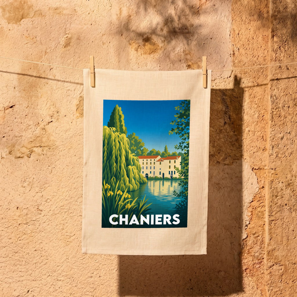 Torchon souvenir de la ville de Chaniers avec une illustration stylisée d'une bâtisse au bord de l'eau.