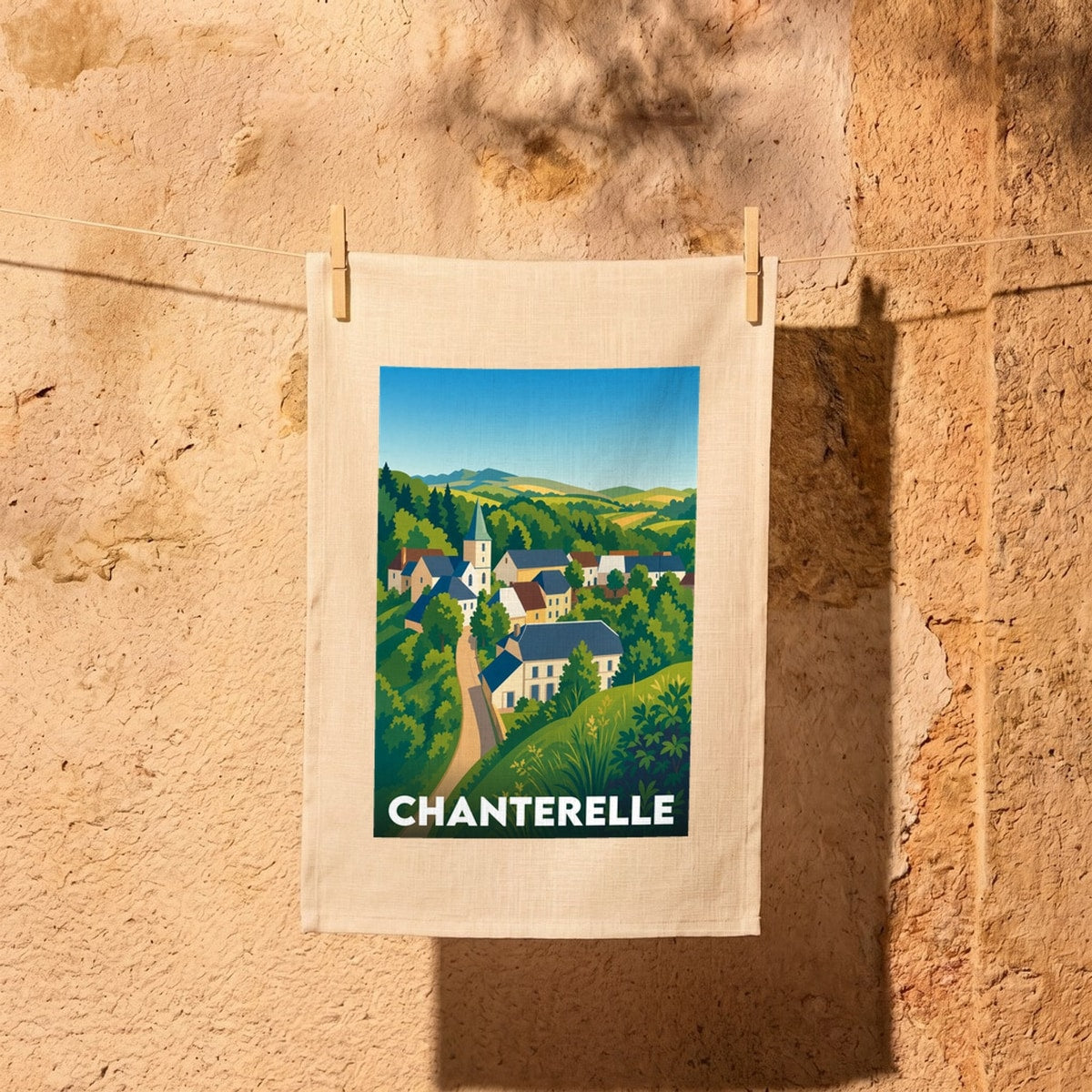 Torchon souvenir de la ville de Chanterelle avec une illustration stylisée du village.