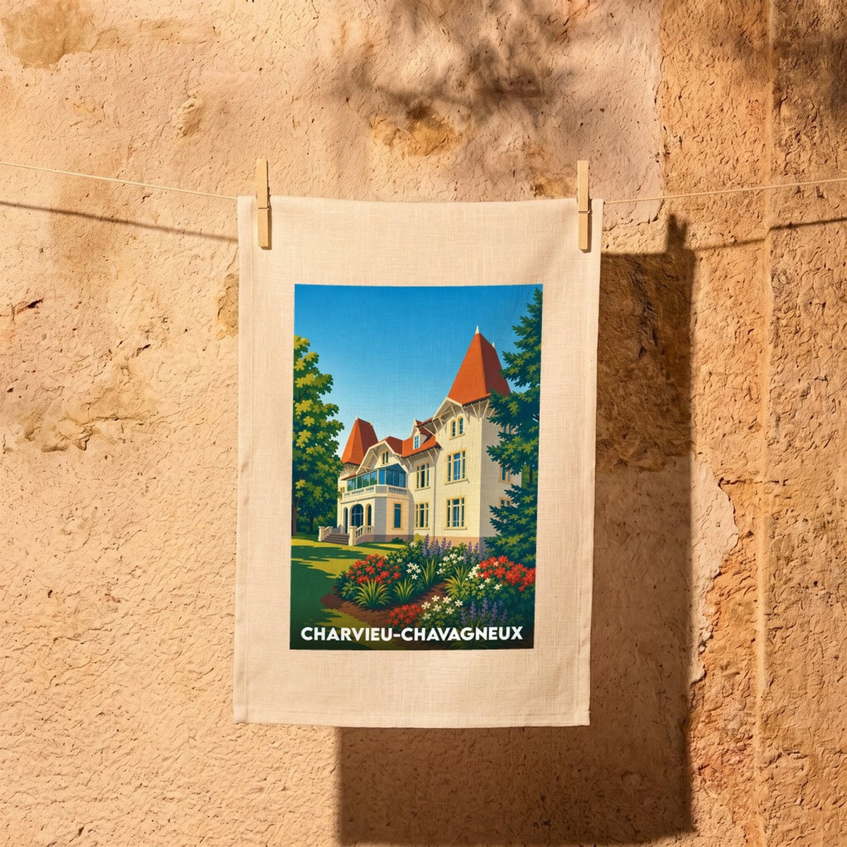 Torchon souvenir de la ville de Charvieu-Chavagneux illustrant une élégante bâtisse au toit rouge entourée de verdure.