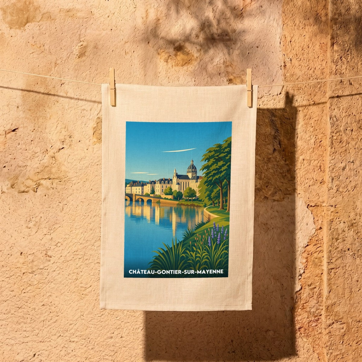 Torchon souvenir de la ville de Château-Gontier-sur-Mayenne avec une illustration stylisée des bords de la Mayenne.
