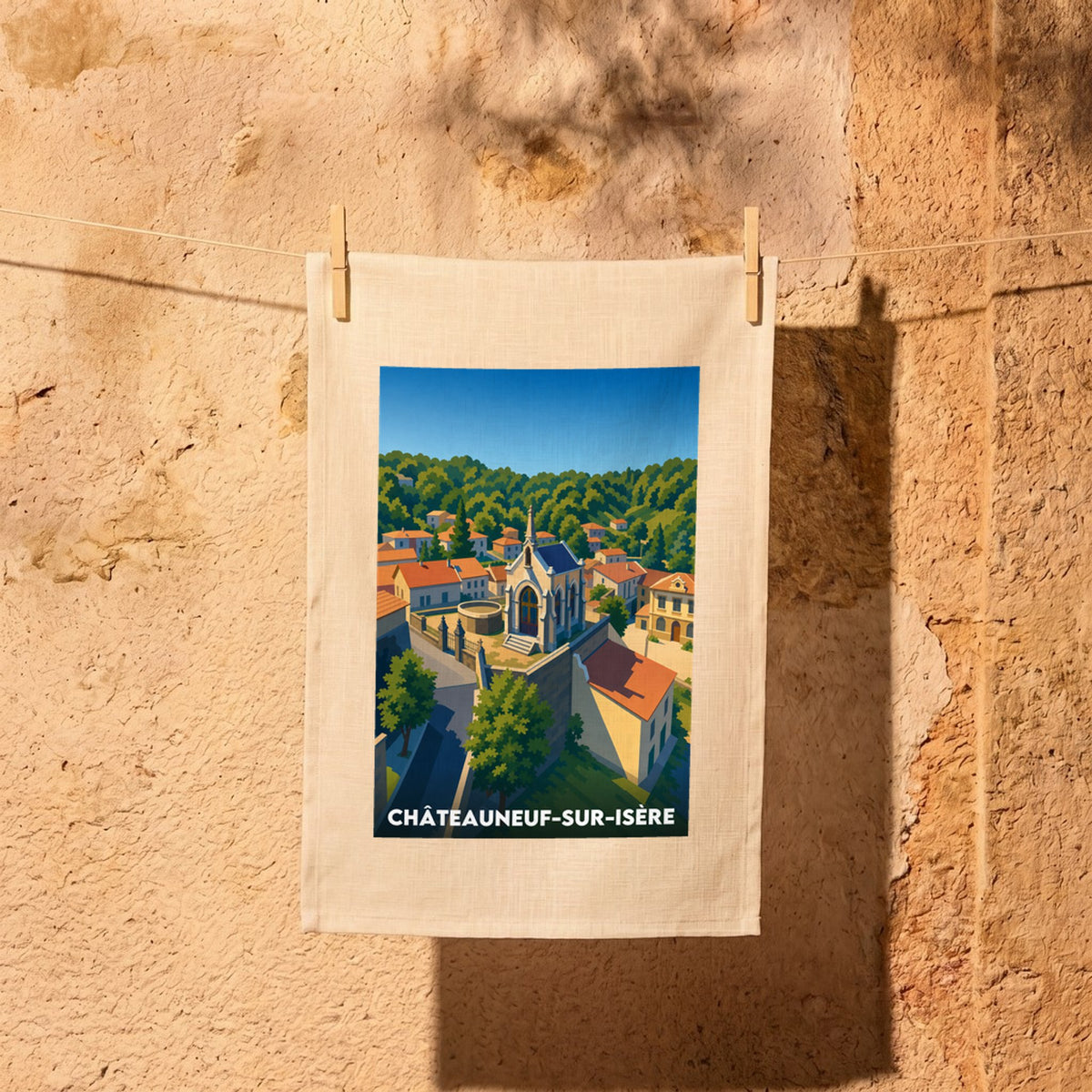 Torchon souvenir de la ville de Châteauneuf-sur-Isère avec une illustration stylisée du village et de son paysage vallonné.