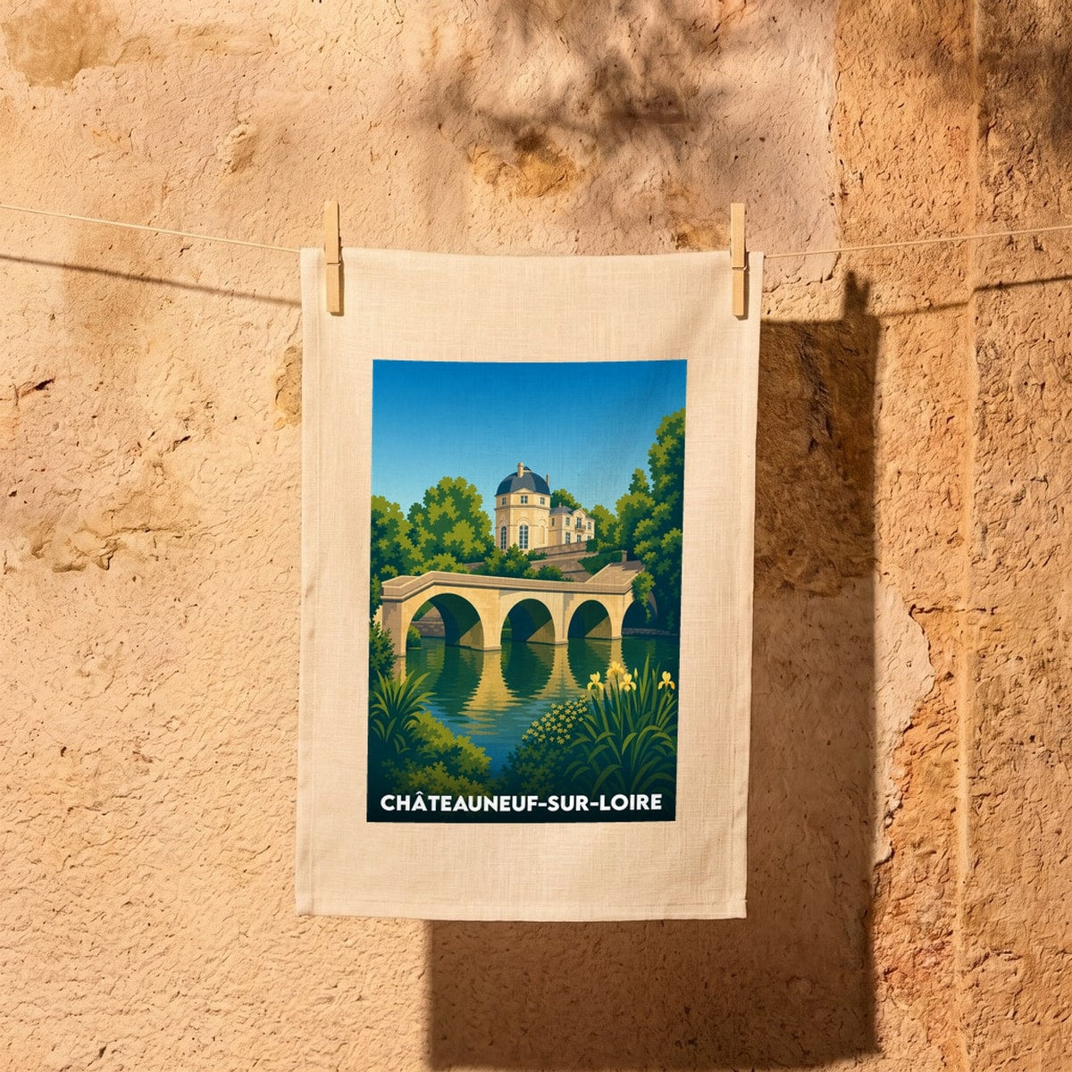 Torchon souvenir de Châteauneuf-sur-Loire avec une illustration stylisée représentant un pont de pierre et un château bordant la Loire.