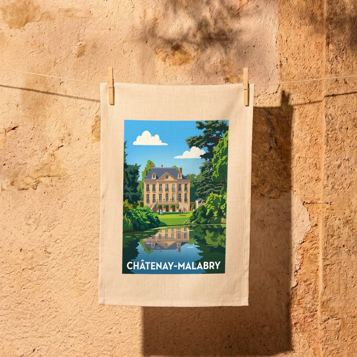Torchon souvenir de la ville de Châtenay-Malabry avec une illustration colorée d'un manoir se reflétant dans l'eau.