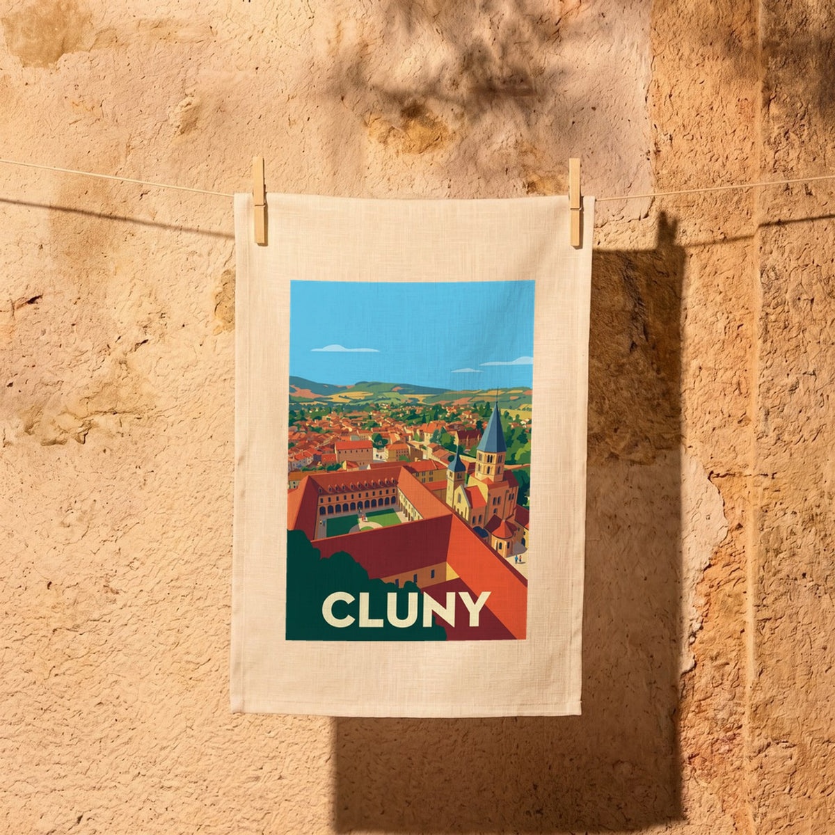 Torchon souvenir de la ville de Cluny avec une illustration stylisée de son abbaye et de ses paysages.