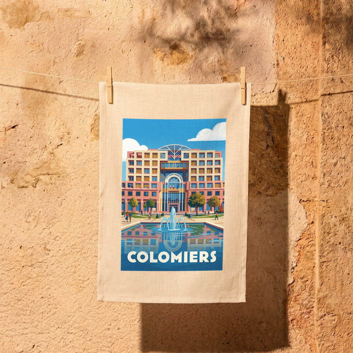 Torchon souvenir de la ville de Colomiers avec une illustration graphique stylisée de son paysage urbain et d'une fontaine.
