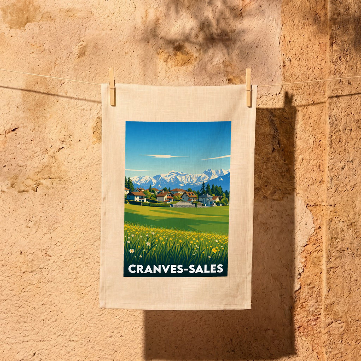 Torchon souvenir de la ville de Cranves-Sales illustré d'un paysage alpin stylisé.