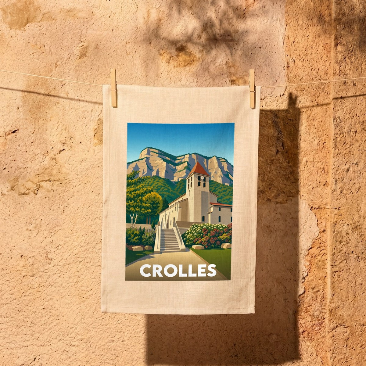 Torchon souvenir de la ville de Crolles illustré d'une église devant une falaise montagneuse.