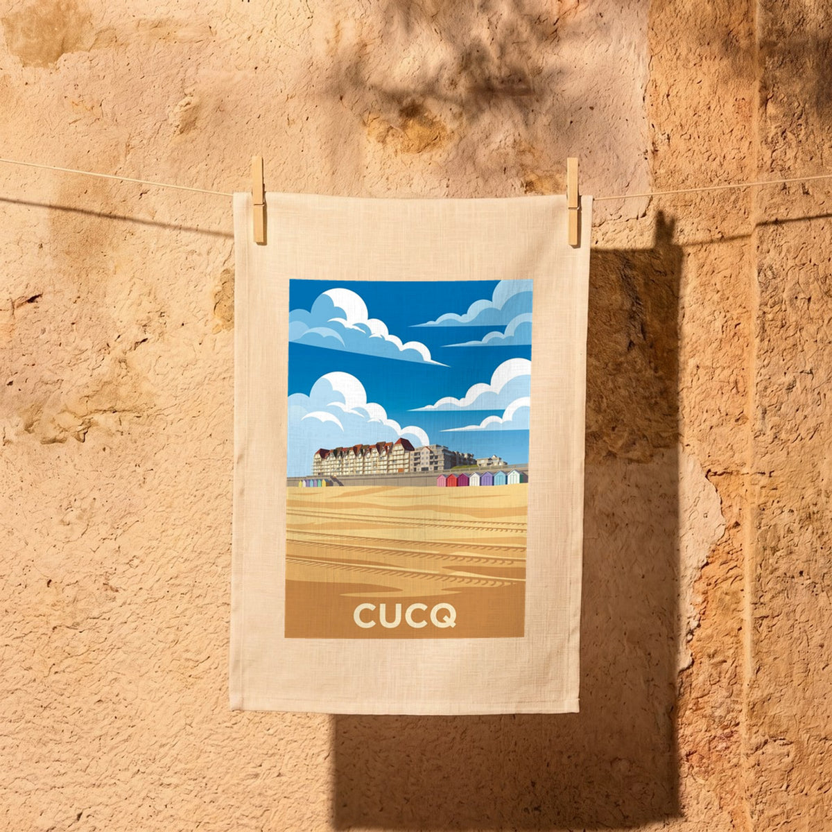 Torchon souvenir de la ville de Cucq avec une illustration stylisée du front de mer.