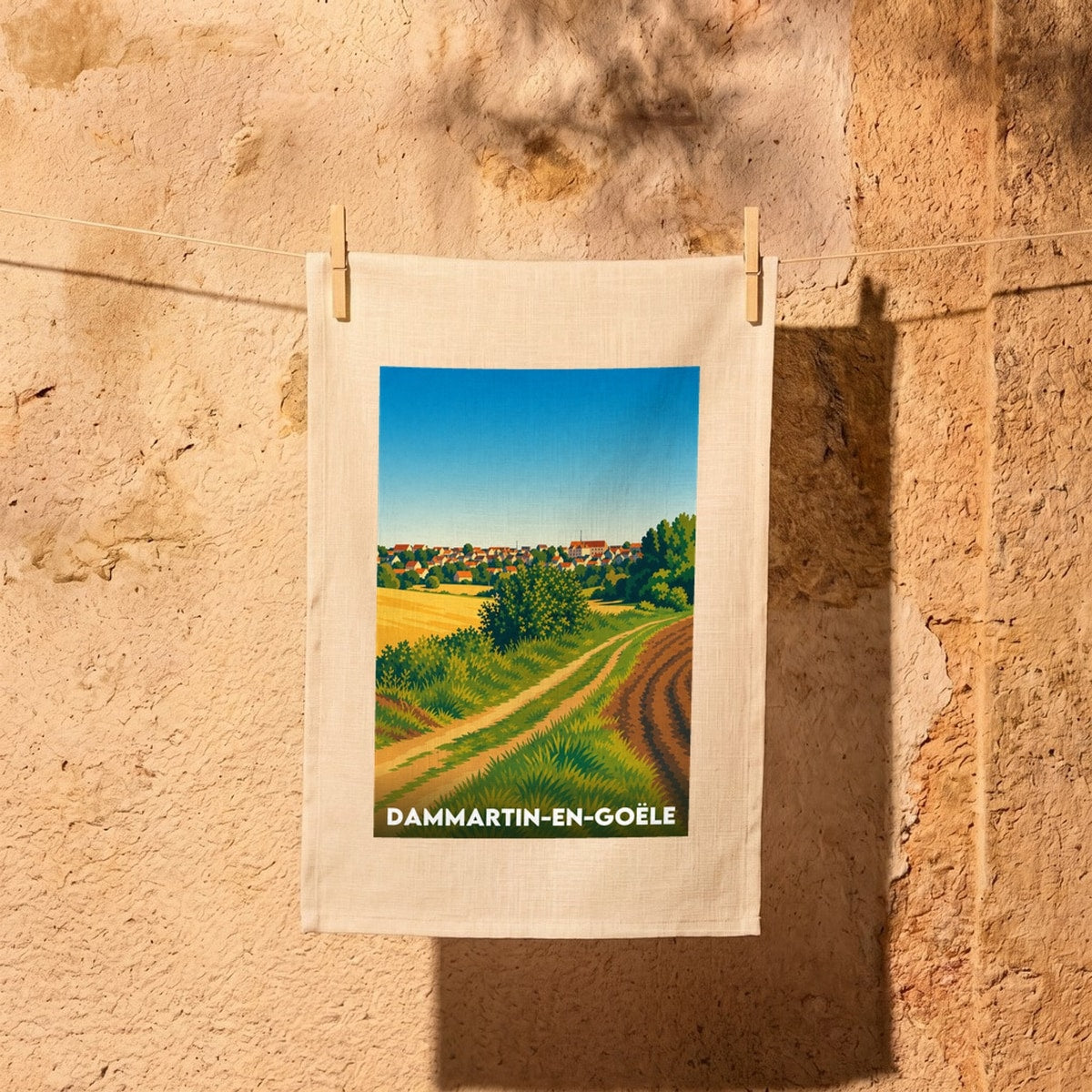 Torchon souvenir de la ville de Dammartin-en-Goële avec une illustration stylisée de ses paysages.
