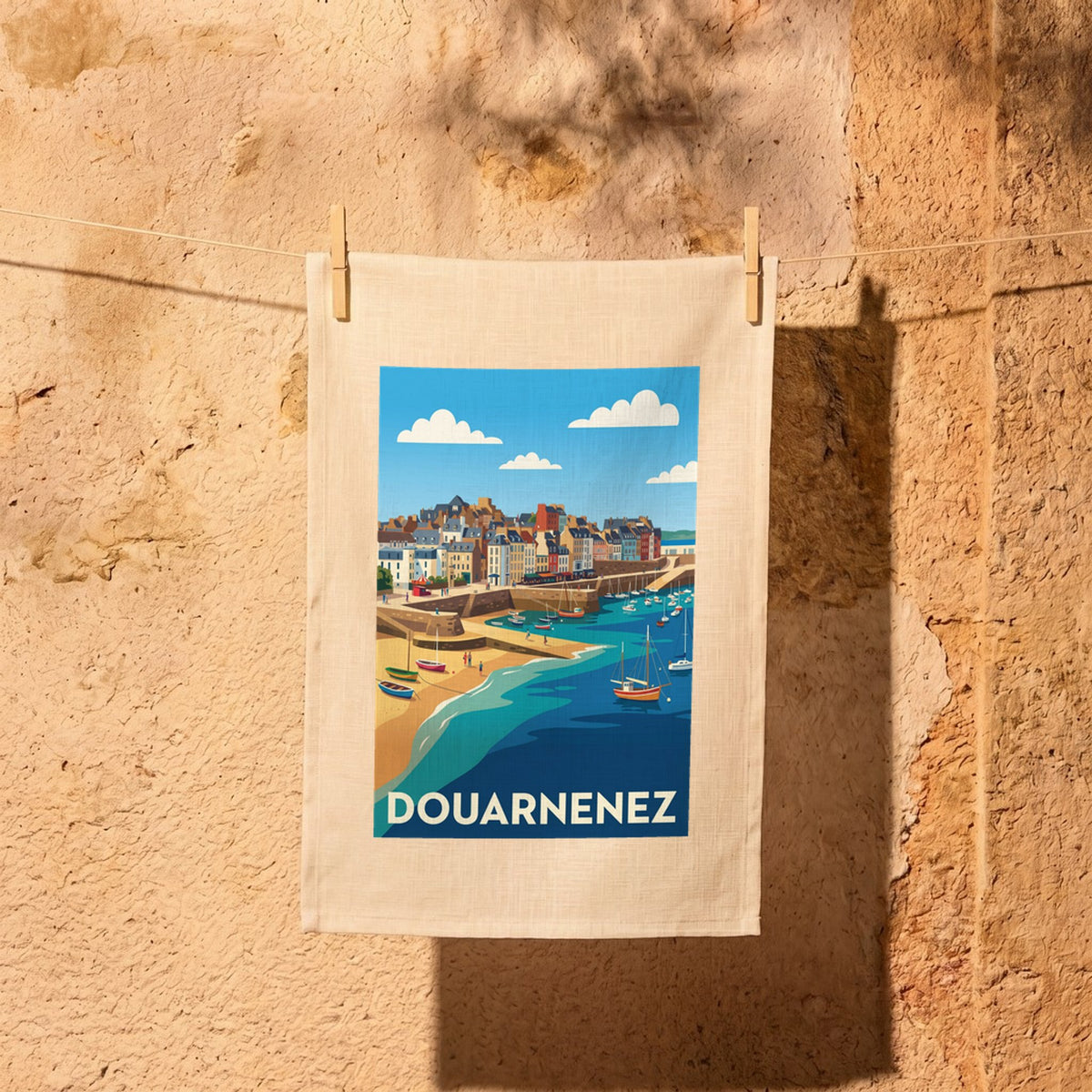 Torchon souvenir de la ville de Douarnenez avec une illustration stylisée de son port et de sa plage.