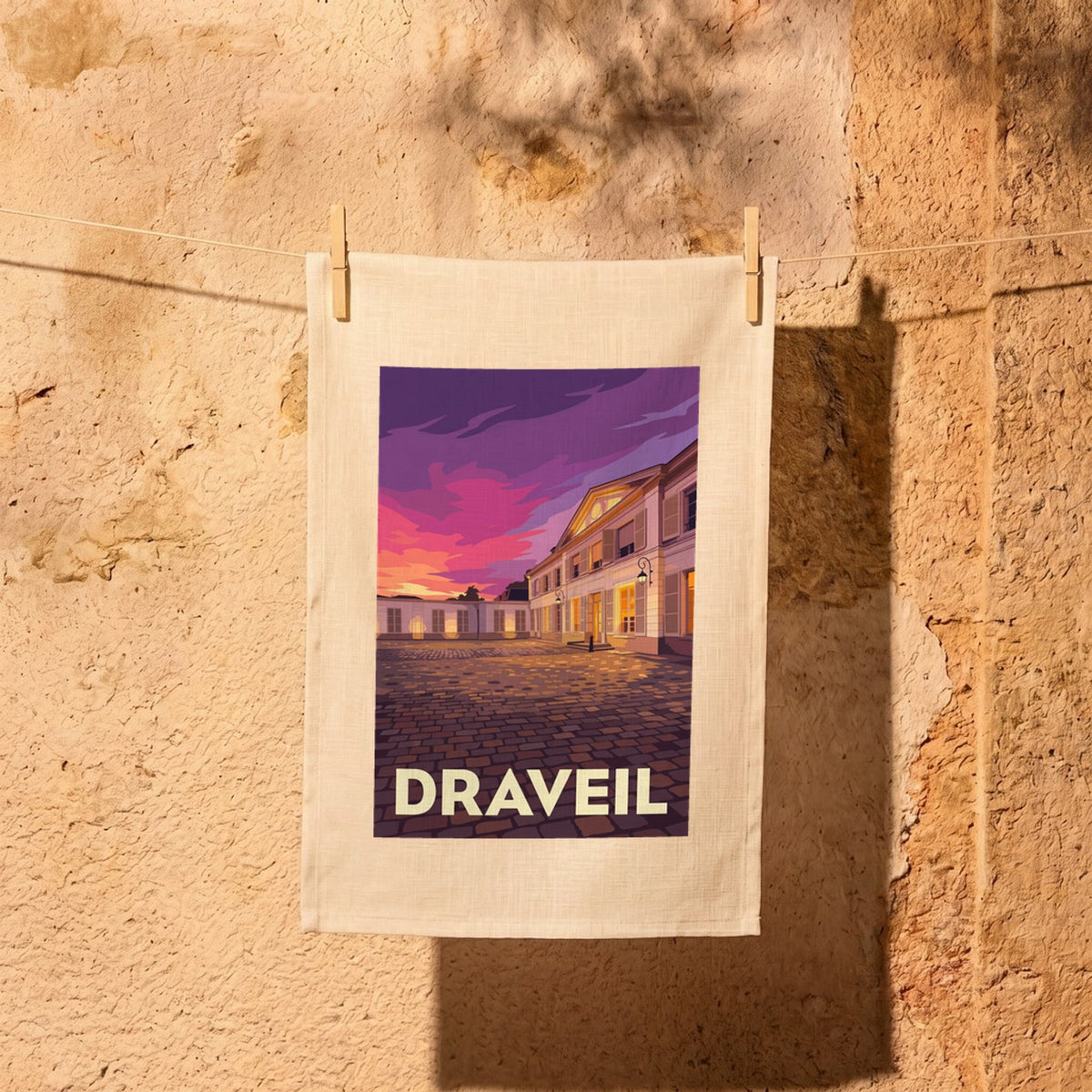 Torchon souvenir de la ville de Draveil avec une illustration stylisée d'un bâtiment au coucher du soleil.