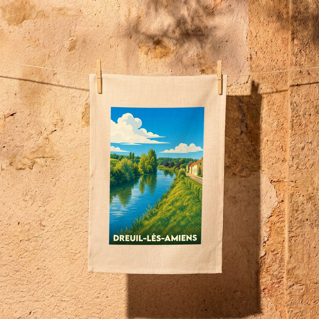 Torchon souvenir de la ville de Dreuil-lès-Amiens illustré d'un paysage de rivière verdoyant.