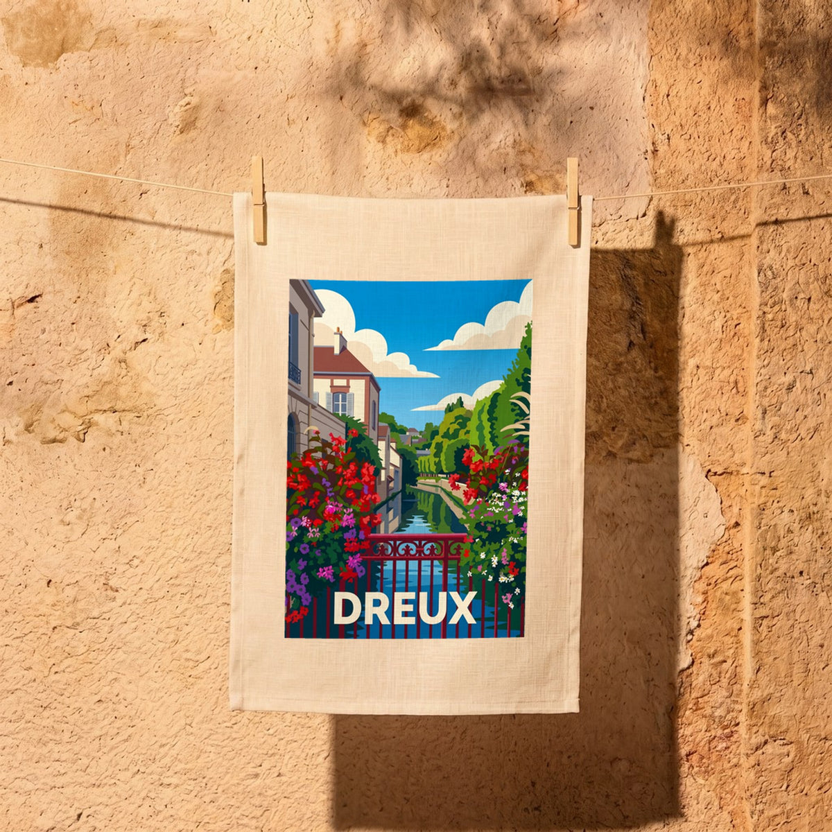Torchon souvenir de la ville de Dreux avec une illustration stylisée d'un canal fleuri.