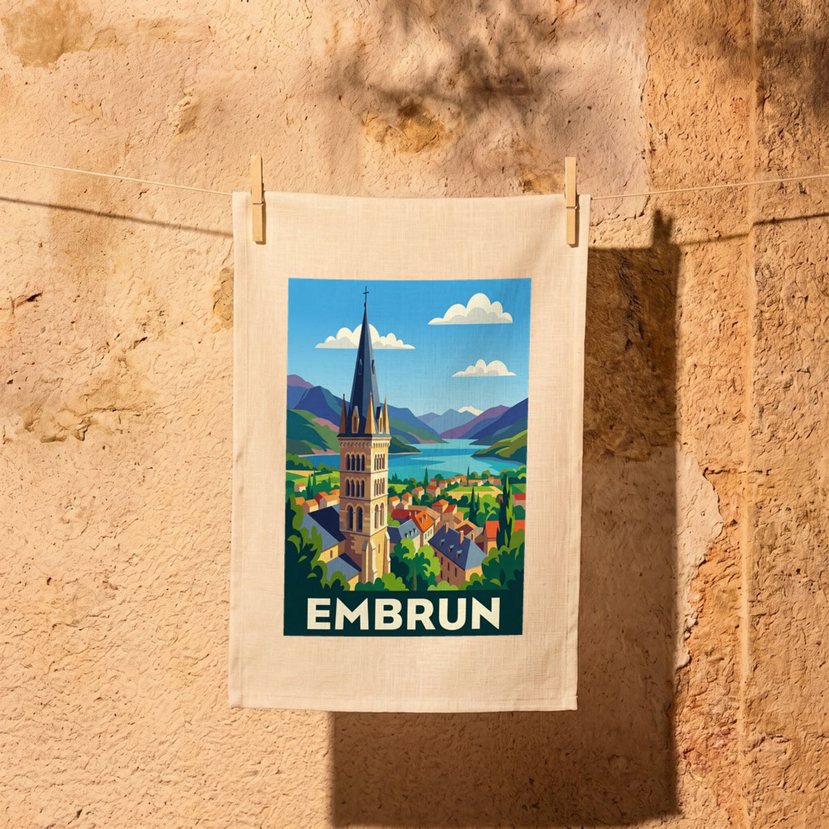 Torchon souvenir de la ville d'Embrun avec une illustration stylisée.