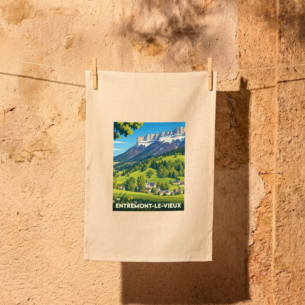 Torchon souvenir de la ville d'Entremont-le-Vieux avec une illustration de paysage montagneux.