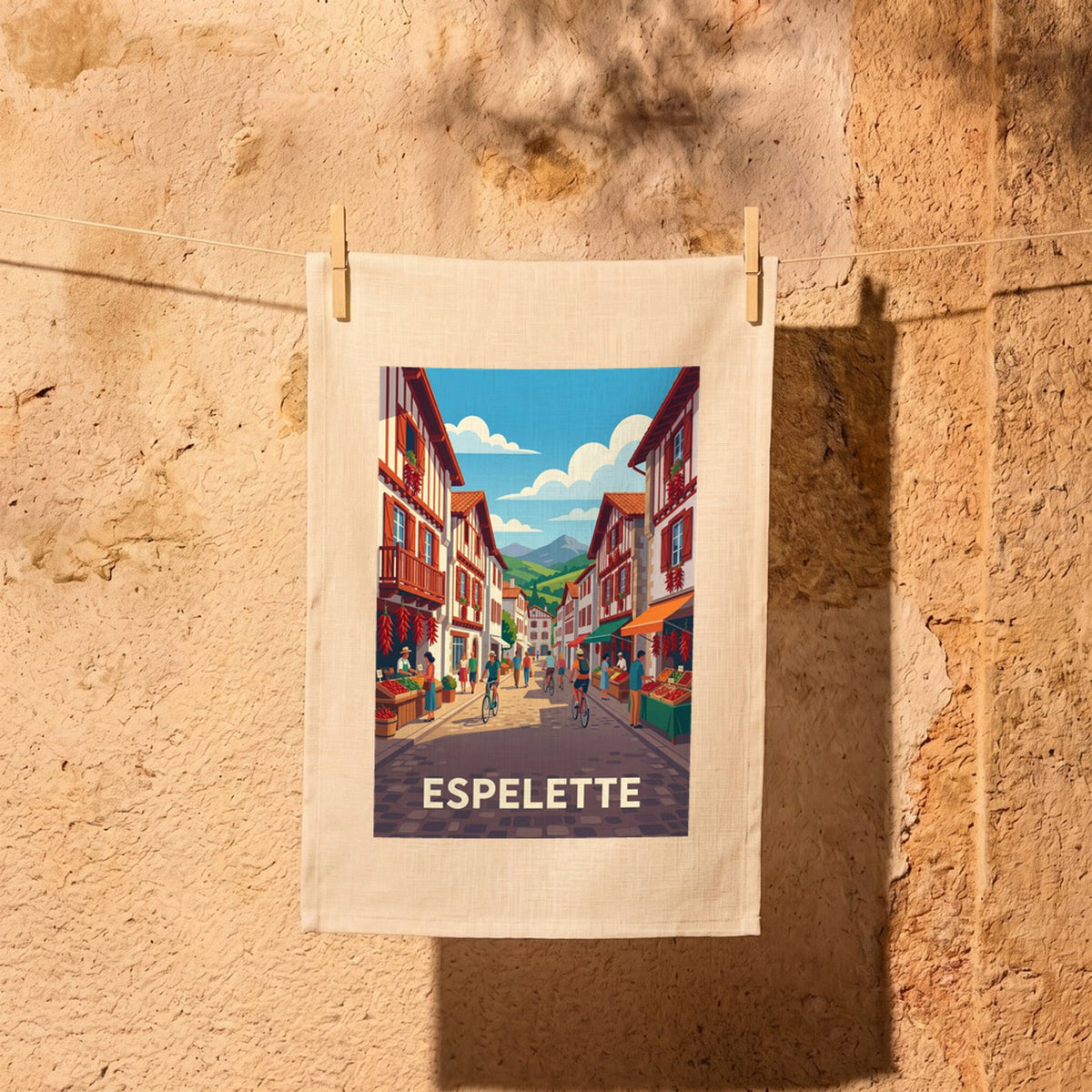 Torchon souvenir de la ville d'Espelette avec une illustration stylisée de ses rues typiques ornées de piments.