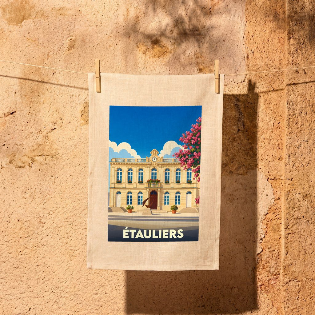 Torchon souvenir de la ville d'Étauliers avec une illustration stylisée de sa mairie sous un ciel bleu.