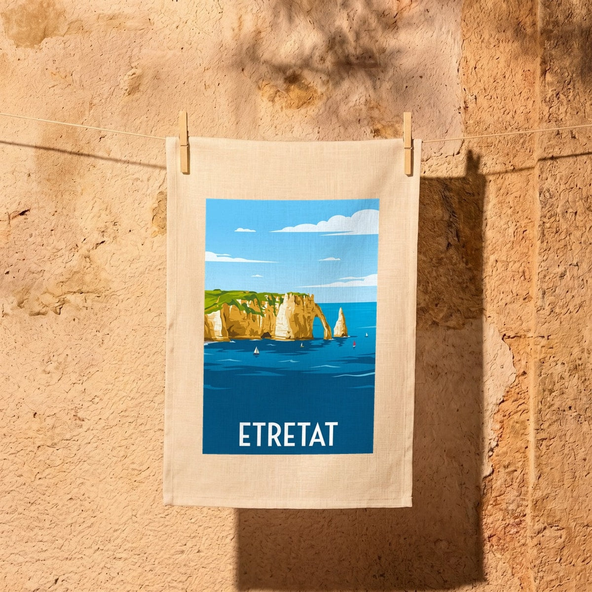Torchon souvenir de la ville d'Étretat avec une illustration stylisée de ses célèbres falaises.