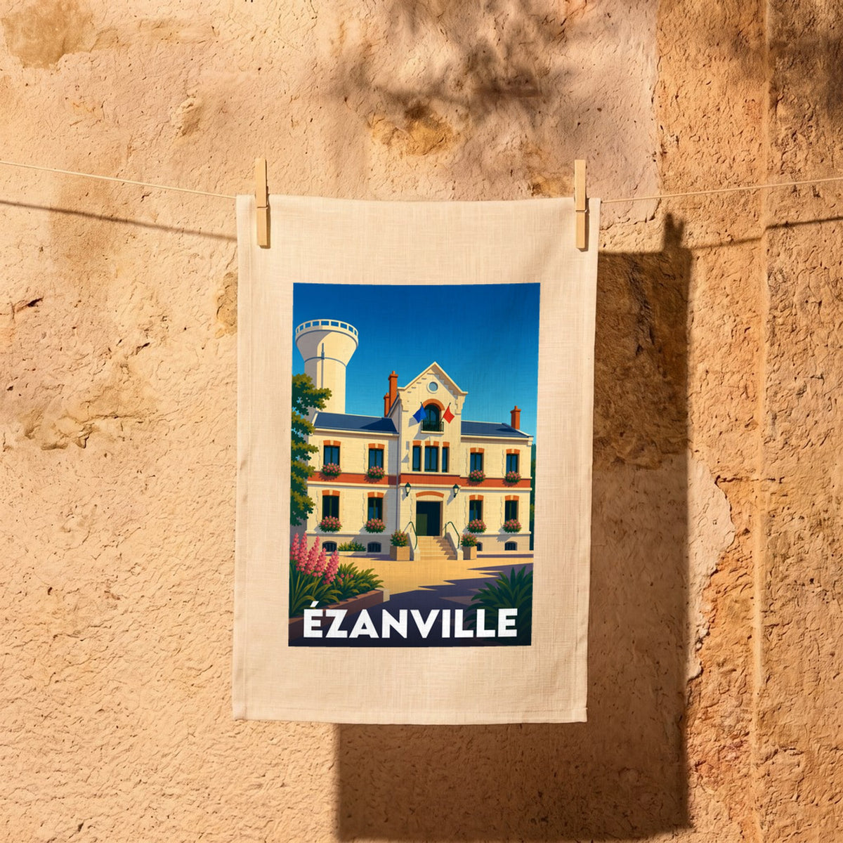 Torchon souvenir de la ville d'Ézanville avec une illustration stylisée de sa mairie.