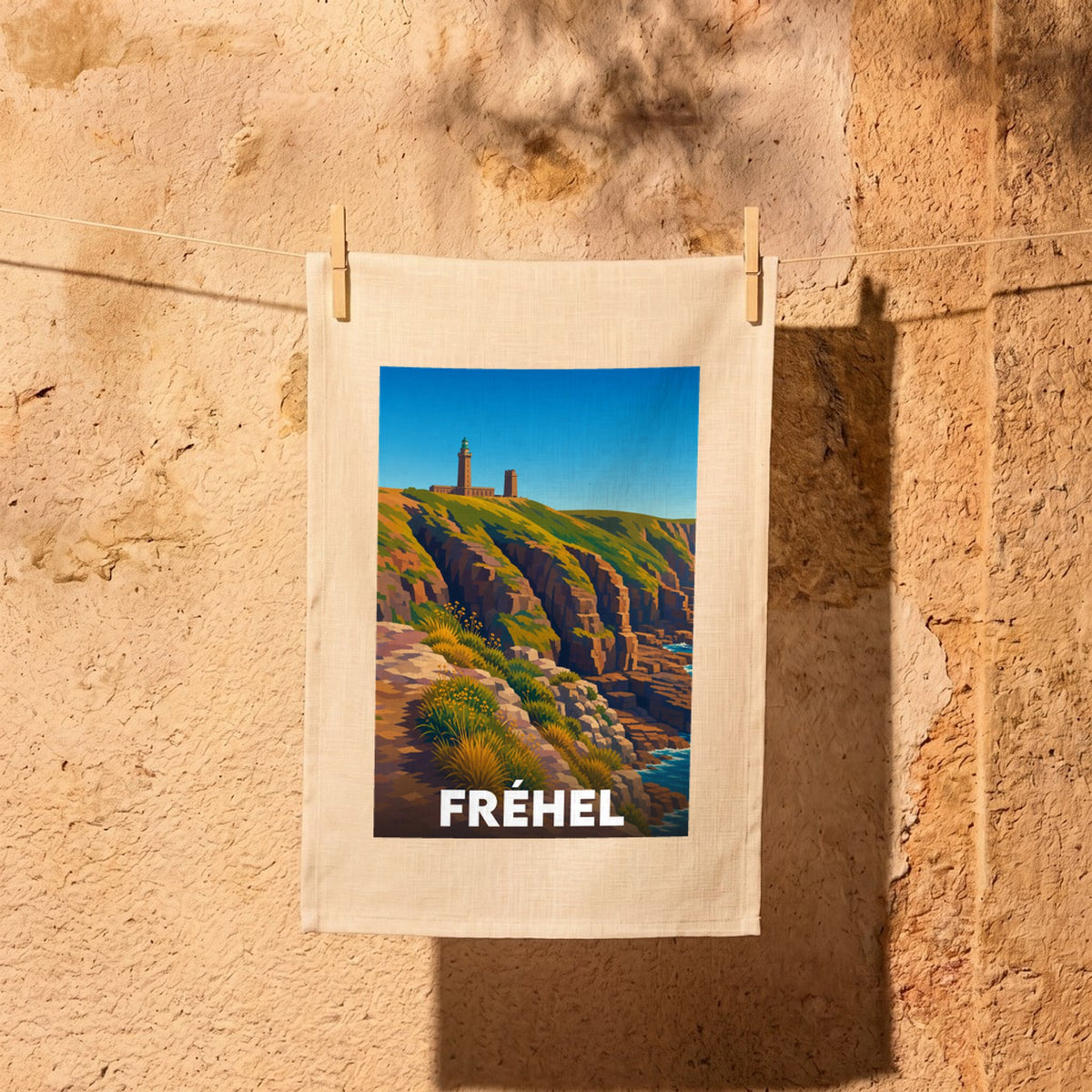 Torchon souvenir de la ville de Fréhel avec une illustration stylisée de ses falaises et de son phare.