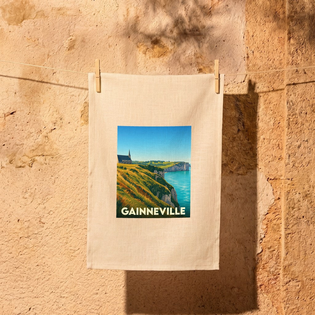 Torchon souvenir de la ville de Gainneville avec une illustration stylisée des falaises d'Étretat.