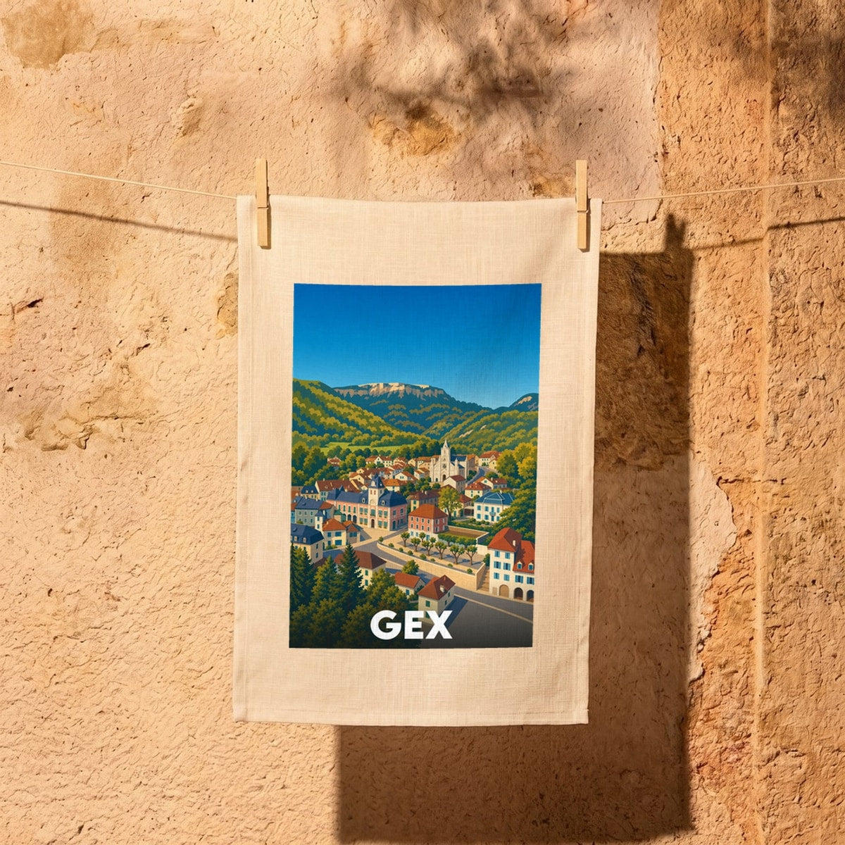 Torchon souvenir de la ville de Gex avec une illustration stylisée de ses paysages et montagnes.