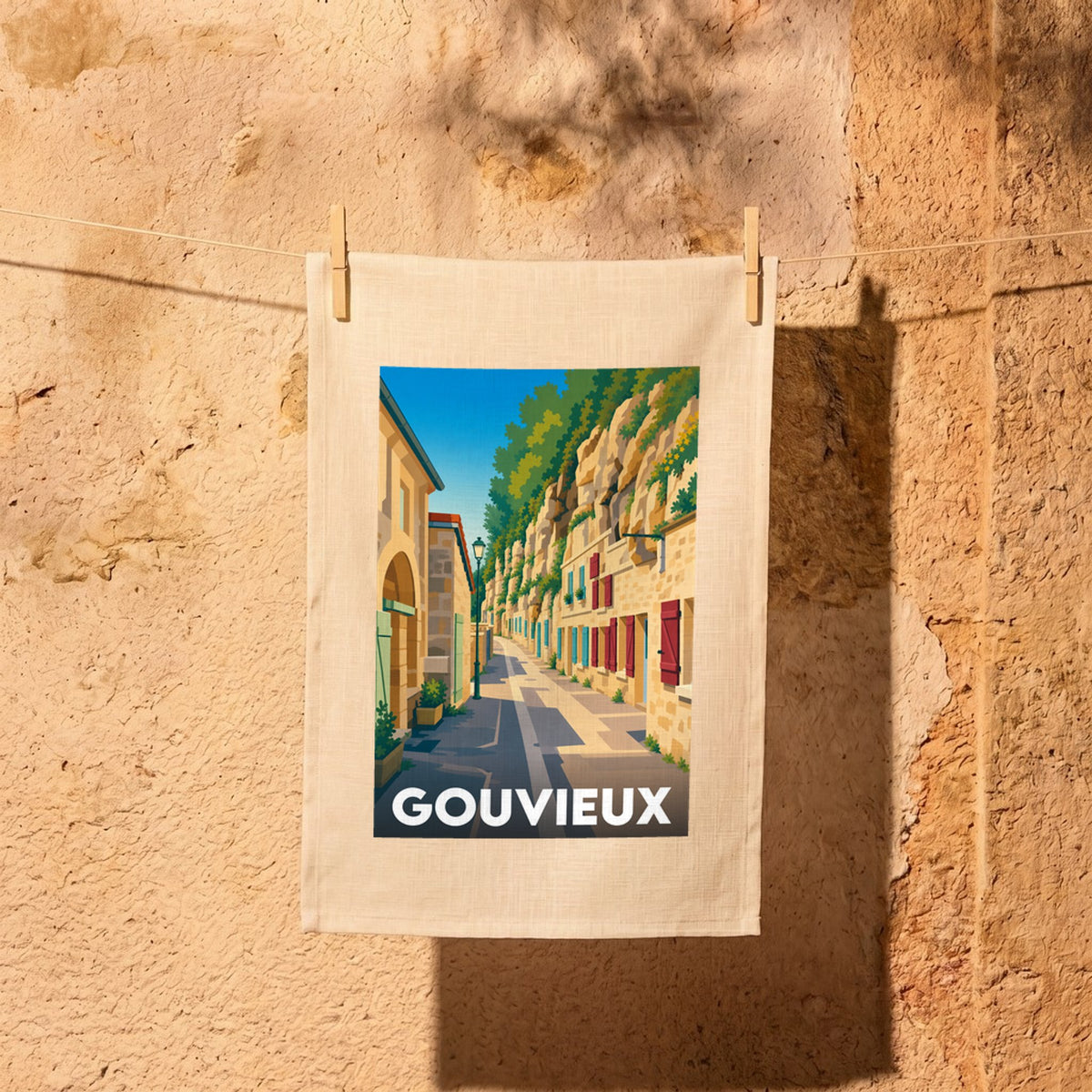 Torchon souvenir de la ville de Gouvieux orné d'une illustration stylisée de ses habitations troglodytiques.