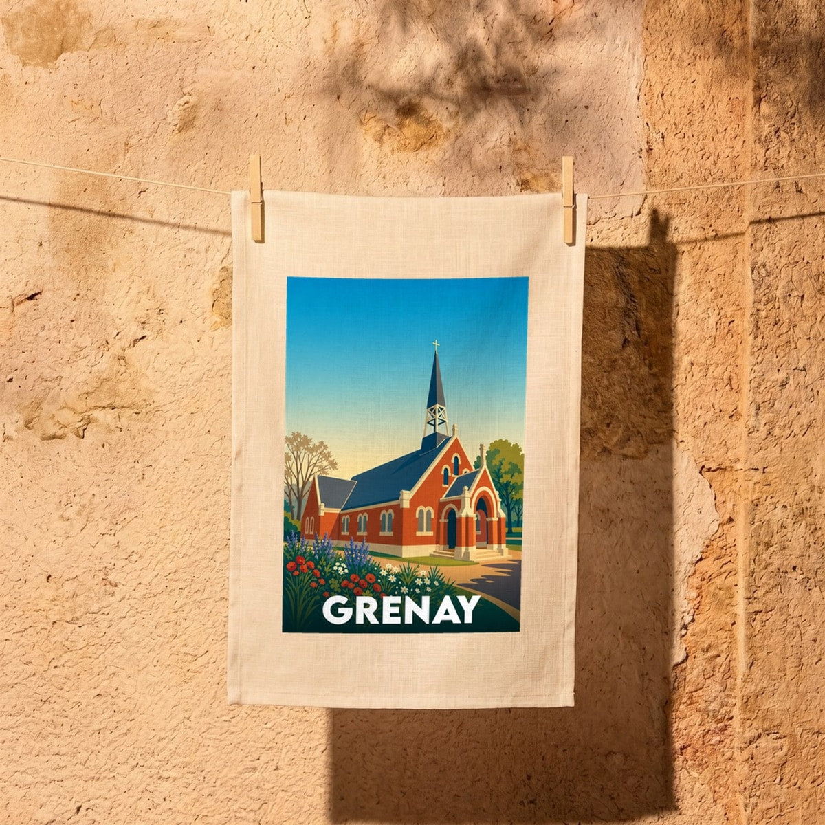 Torchon souvenir de la ville de Grenay orné d'une illustration stylisée d'une église en briques rouges.