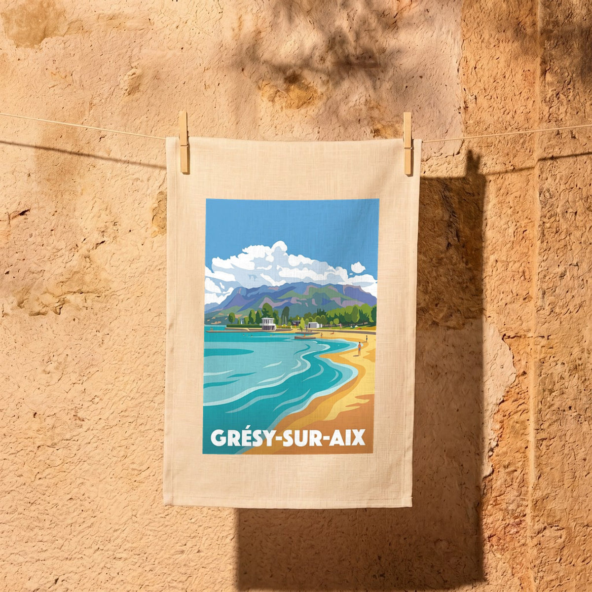 Torchon souvenir de la ville de Grésy-sur-Aix avec une illustration stylisée d'un paysage de lac et de montagnes.