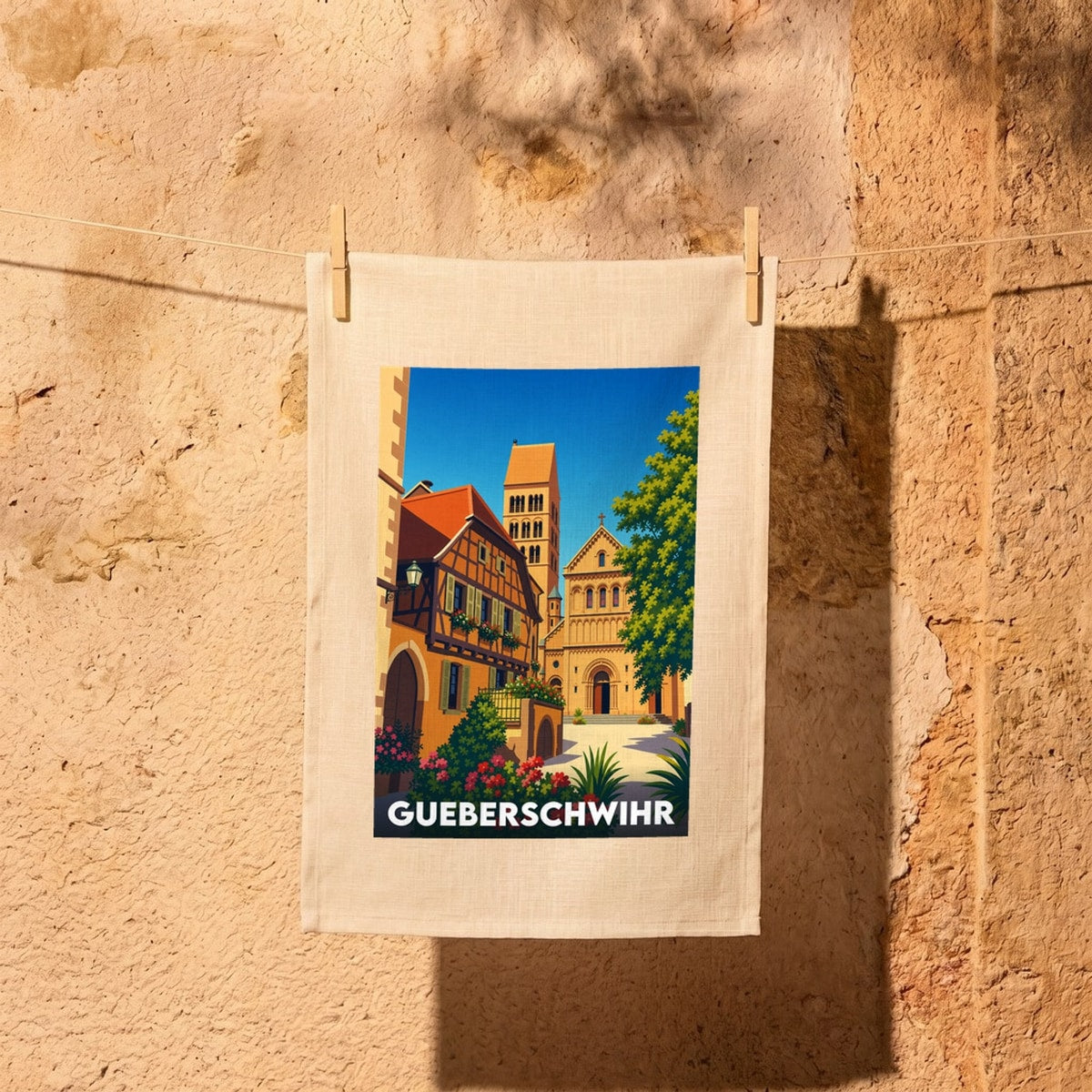 Torchon souvenir de la ville de Gueberschwihr avec une illustration stylisée de son architecture typique.