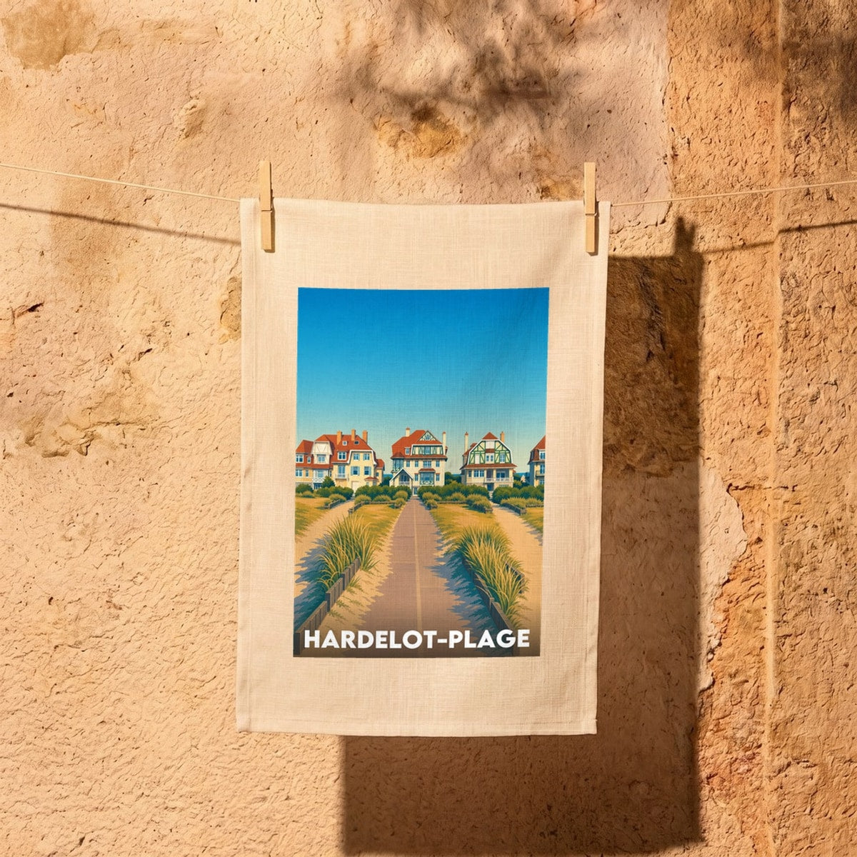 Torchon souvenir de la ville de Hardelot-Plage avec une illustration stylisée de villas côtières.