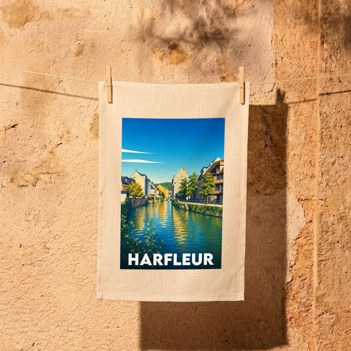 Torchon souvenir de la ville de Harfleur illustré d'une vue stylisée et colorée de ses quais.