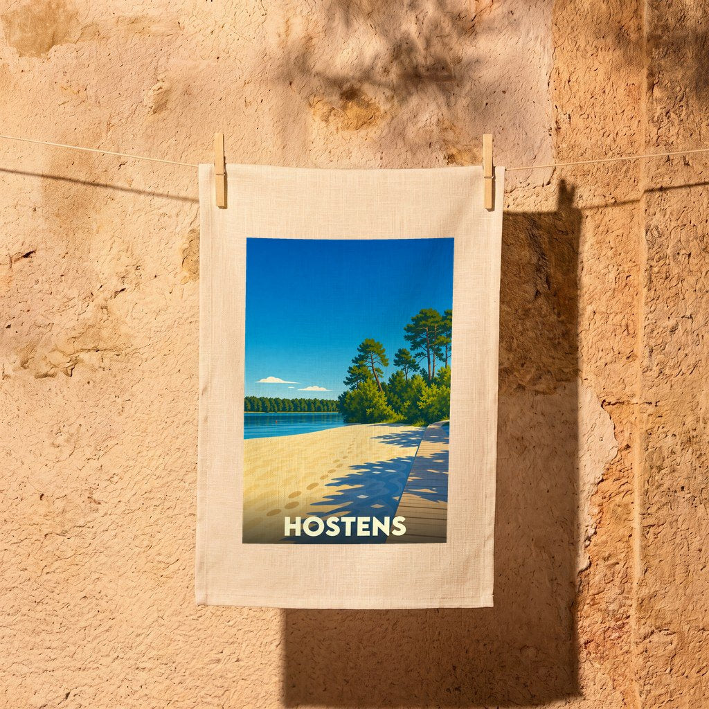 Torchon souvenir de la ville de Hostens avec une illustration stylisée d'un lac bordé de pins.