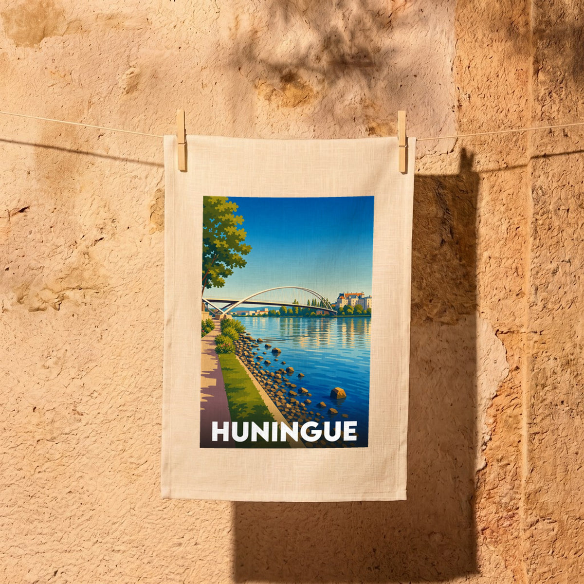 Torchon souvenir de la ville de Huningue illustré d'un dessin stylisé représentant sa passerelle sur le Rhin.