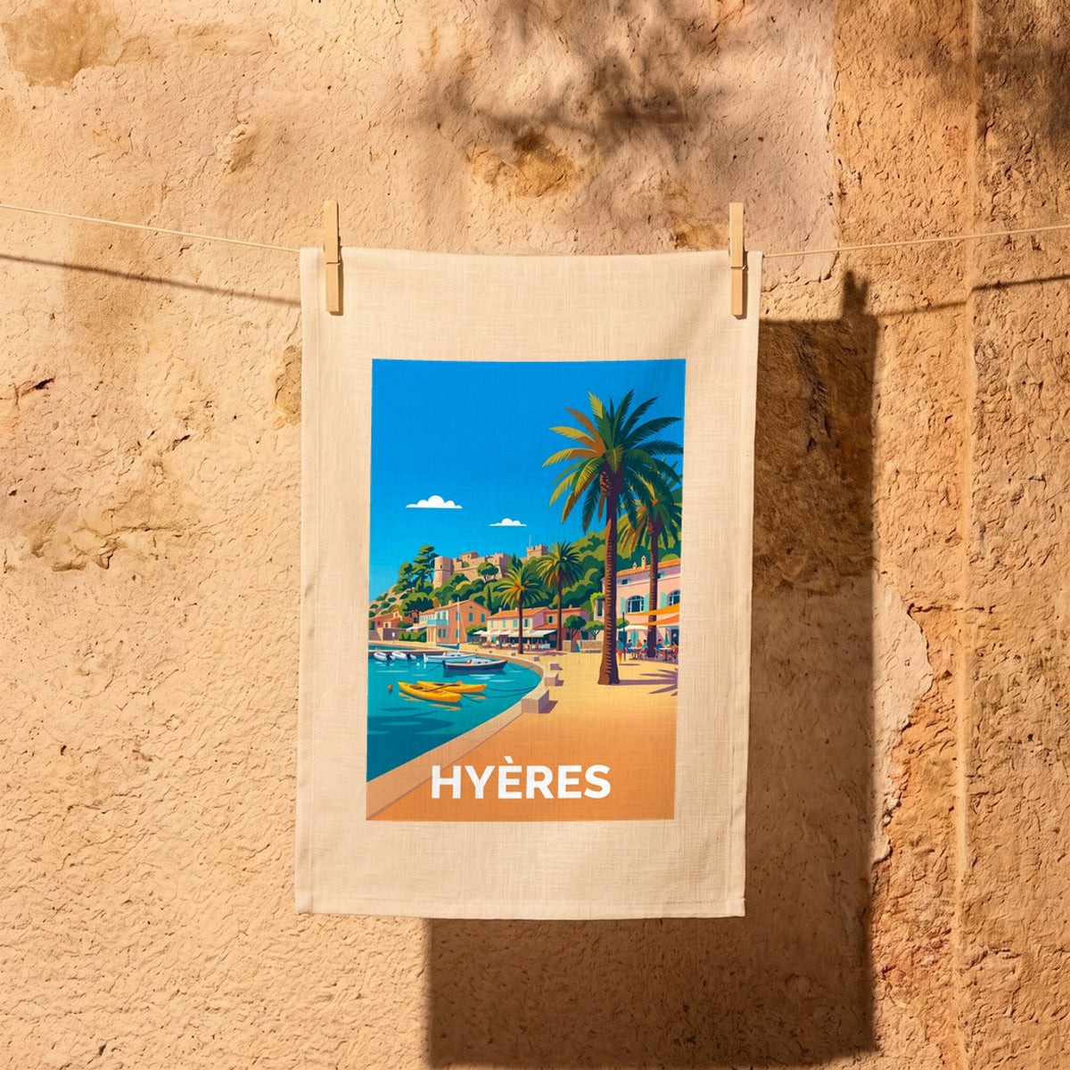 Torchon souvenir de la ville de Hyères avec une illustration stylisée de son bord de mer ensoleillé.