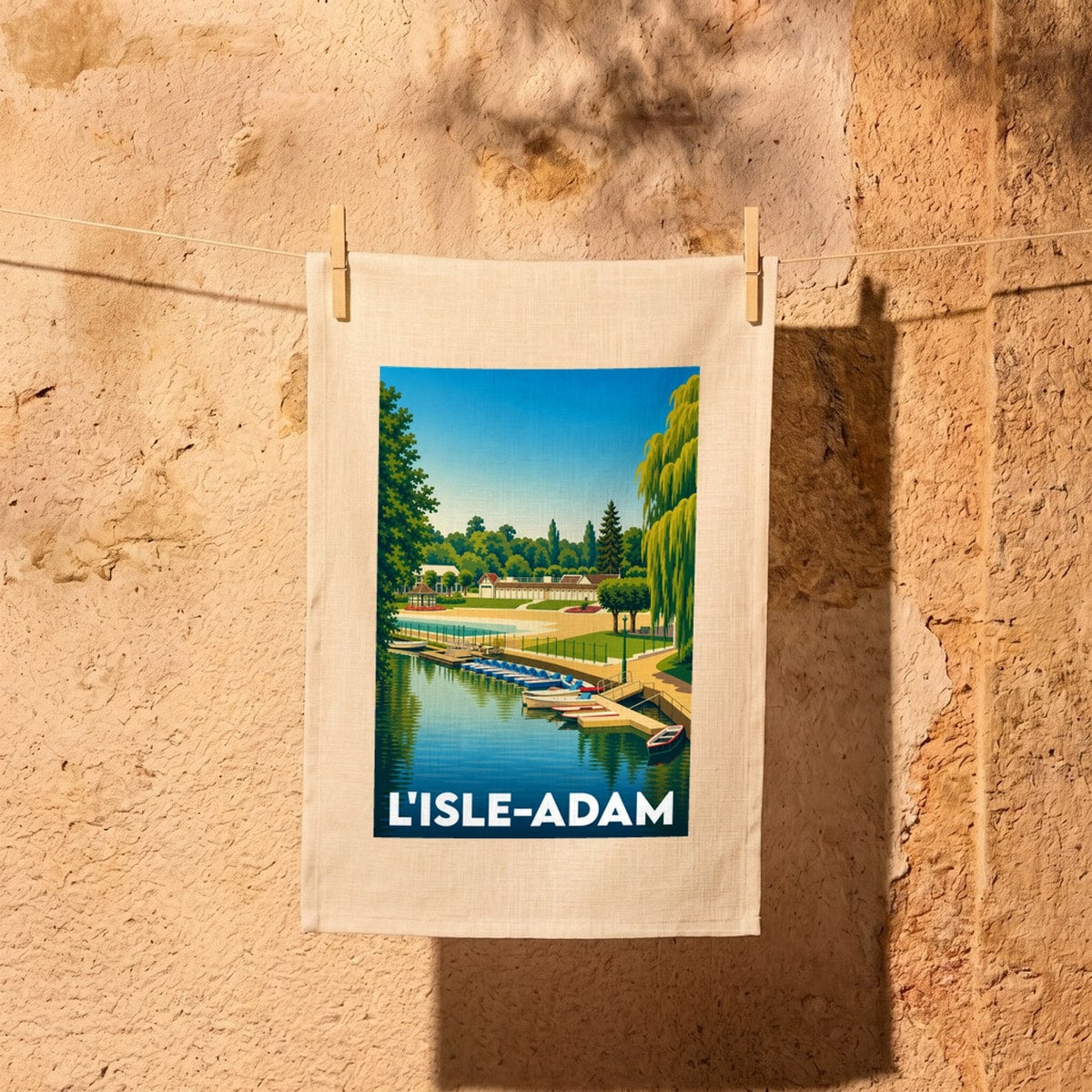 Torchon souvenir de la ville de L'Isle-Adam avec une illustration stylisée de sa plage et de son port.