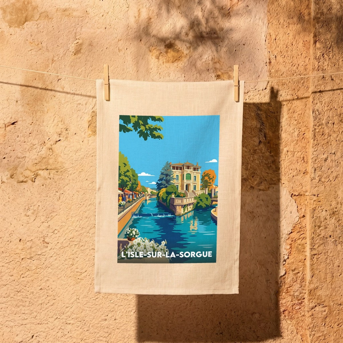 Torchon souvenir de la ville de L'Isle-sur-la-Sorgue avec une illustration colorée et stylisée.