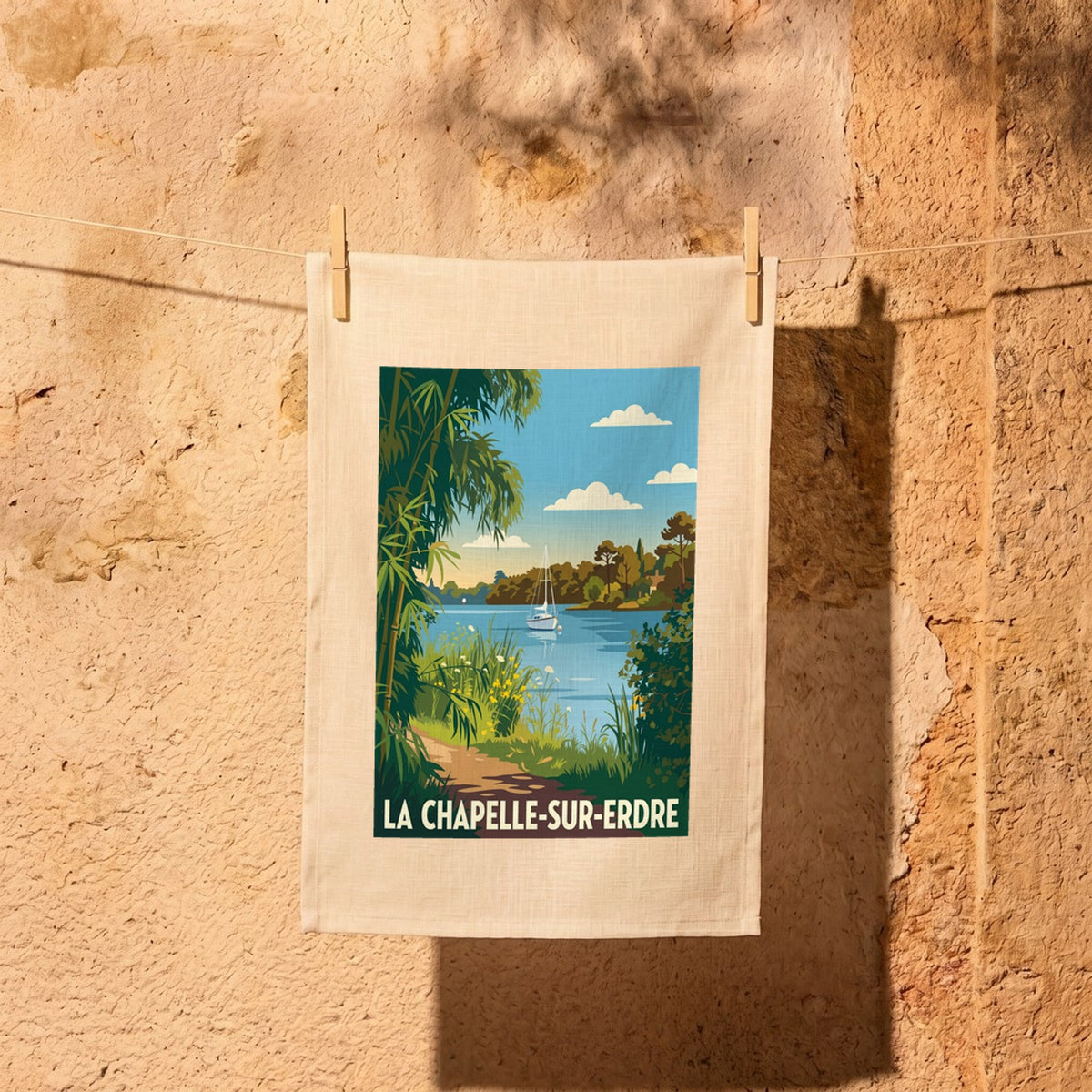 Torchon souvenir de la ville de La Chapelle-sur-Erdre avec une illustration stylisée d'un paysage au bord de l'eau.
